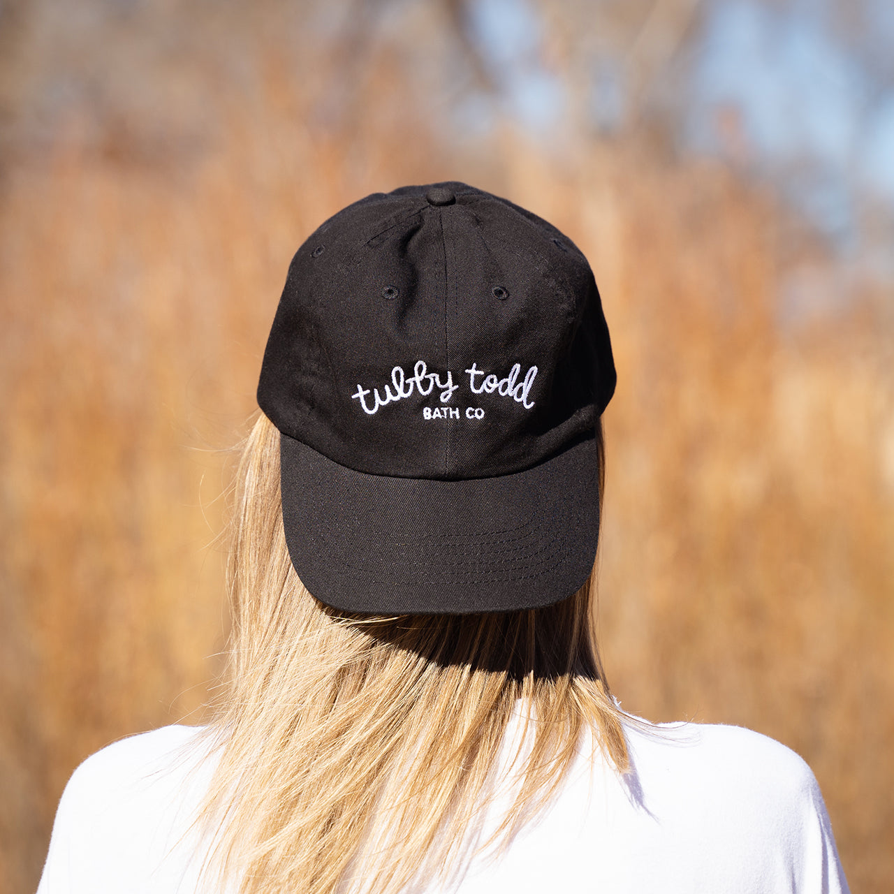 Back shot of a woman with a mama hat on her back.